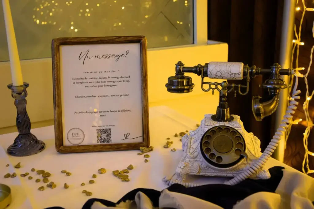 Livre d'or audio : téléphone vintage et panneau explicatif sur une table de mariage
