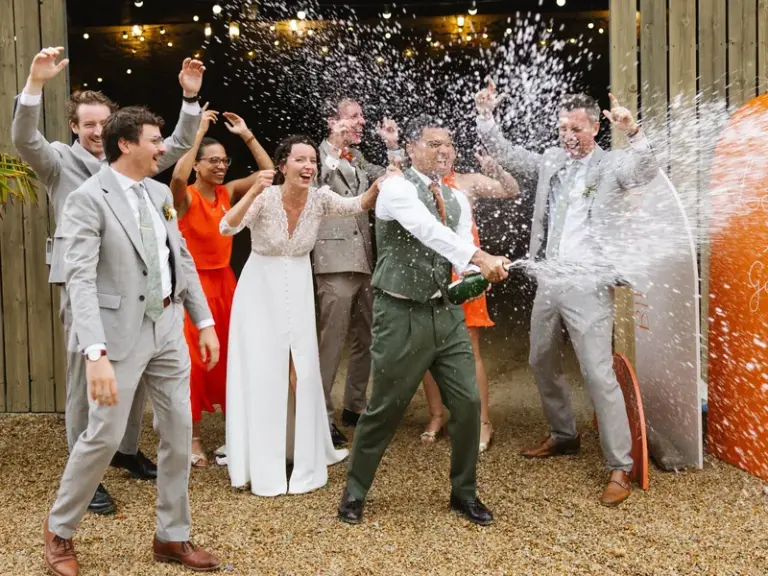 Léa et Gabriel ouvrant une bouteille de champagne entourés de leurs invités au Château de Pratulo, à Cléden-Poher